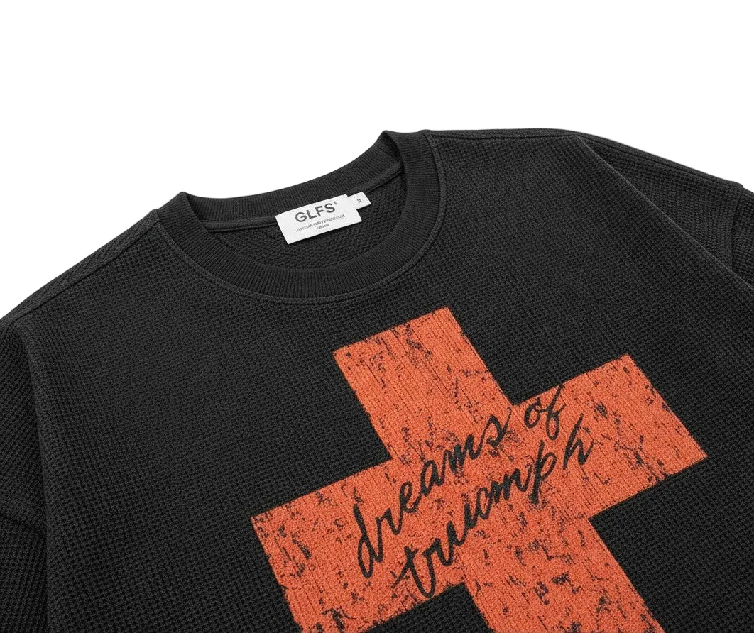 PAKSHI black waffle knit long-sleeve t-shirt with a distressed orange cross graphic and script text