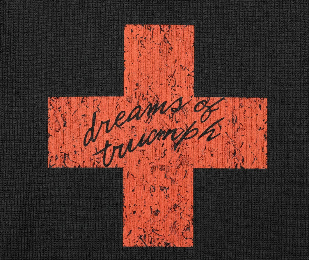 PAKSHI black waffle knit long-sleeve shirt featuring a distressed red cross graphic with dreams of triumph text