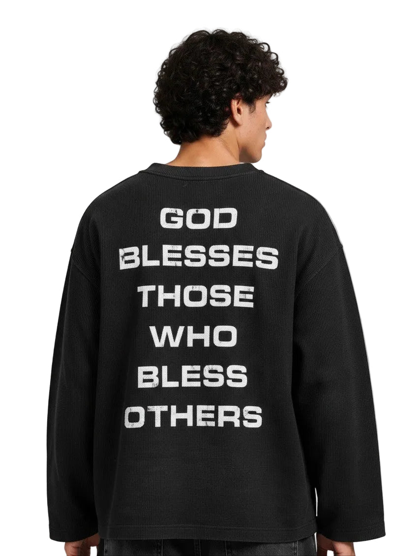 PAKSHI black waffle knit long-sleeve shirt with white distressed text on the back, worn by a man from behind.