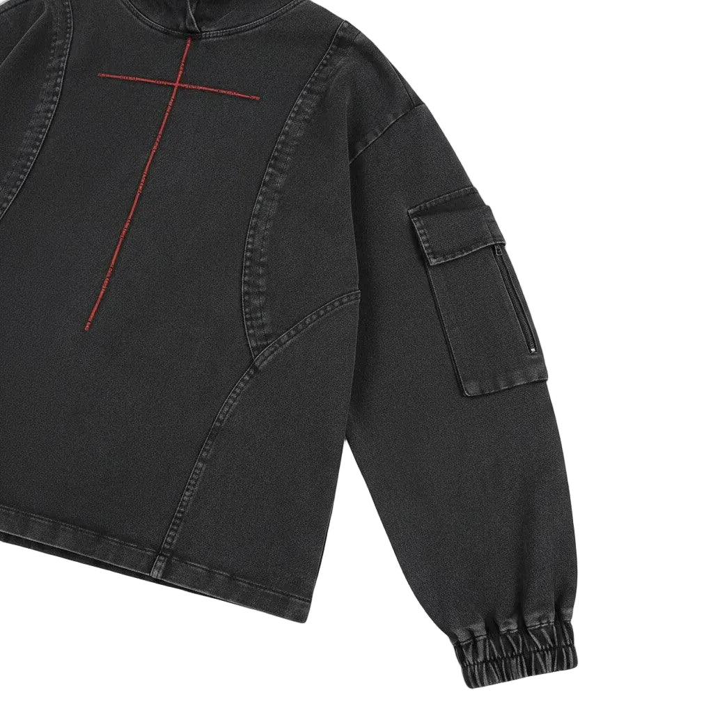 PAKSHI cropped utility denim hoodie in washed black with red cross embroidery and a zippered sleeve cargo pocket.