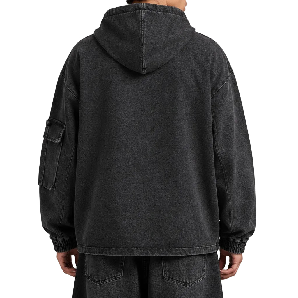 Back view of a PAKSHI cropped utility denim hoodie in washed black with a side cargo pocket and elastic cuffs.