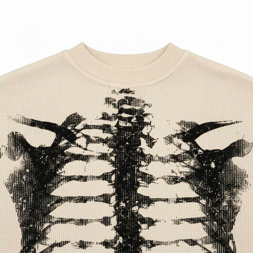 PAKSHI waffle knit long-sleeve t-shirt in beige featuring a black distressed skeleton rib cage graphic print.