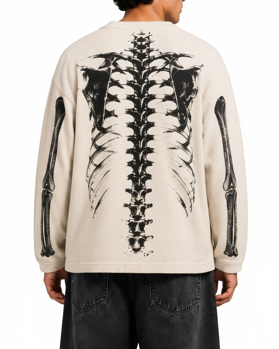 Back view of a PAKSHI beige waffle knit long-sleeve t-shirt featuring a large black skeleton graphic print.
