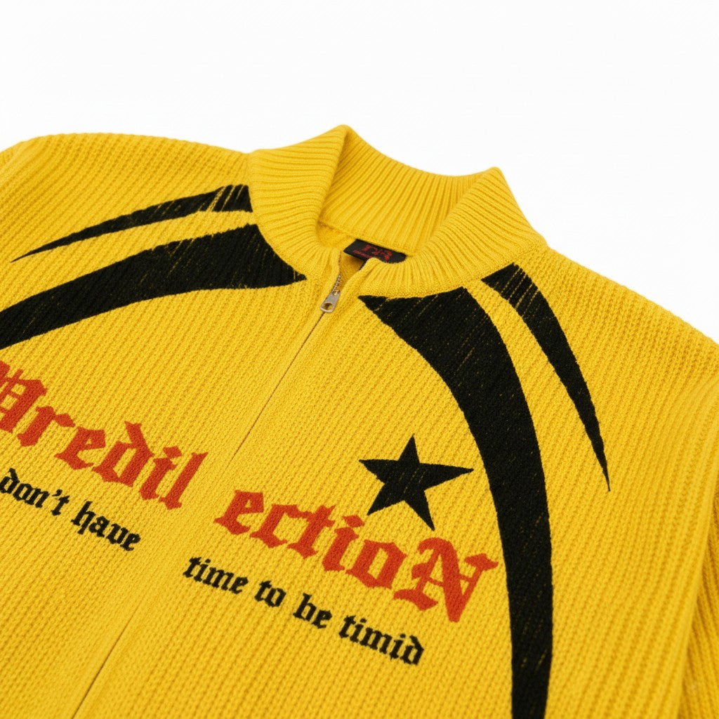 PAKSHI yellow knit sweater jacket with black graphic accents, star detail, and gothic text on a zip-up front.
